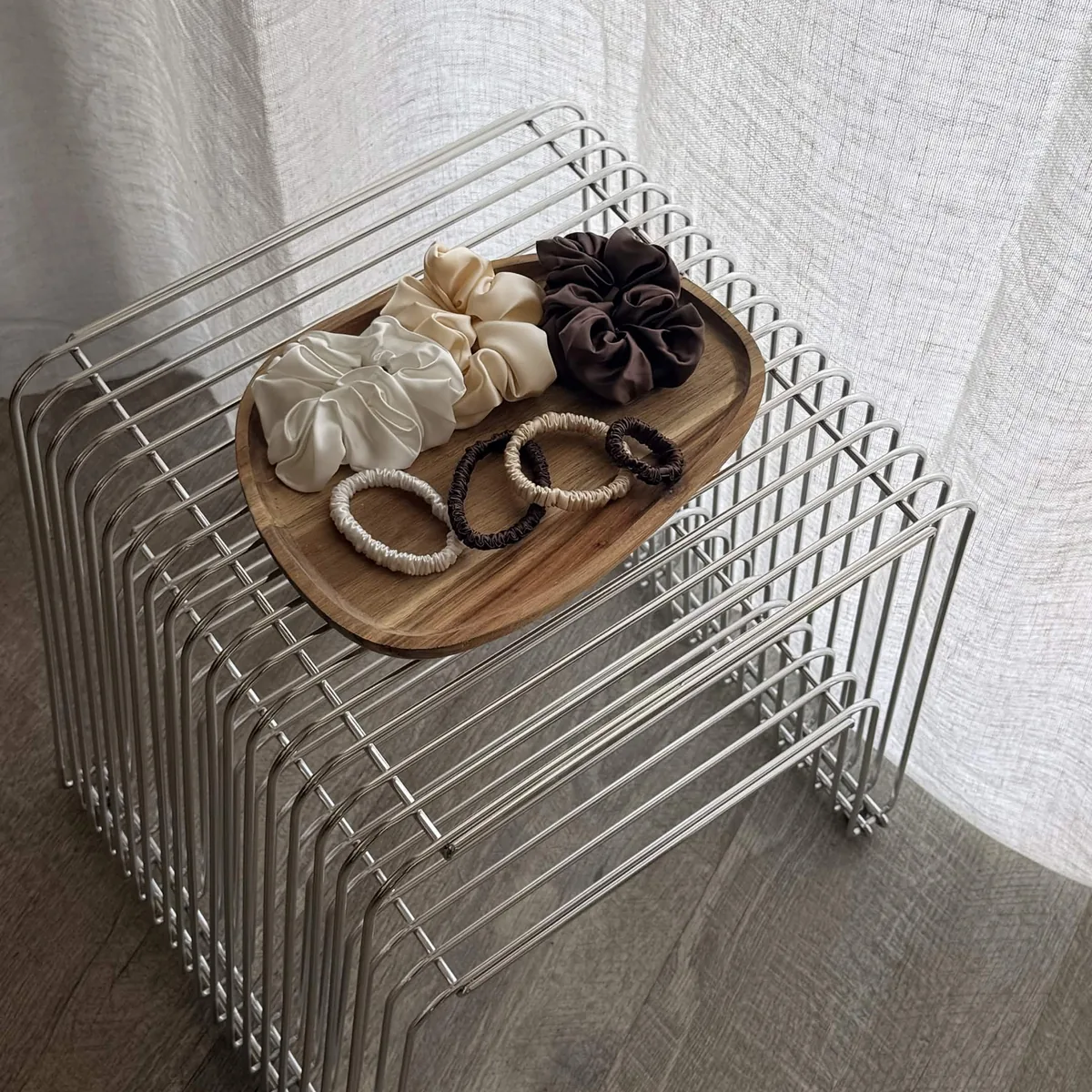 Seiden-Scrunchies und Seiden-Haargummis auf einem Holztablett
